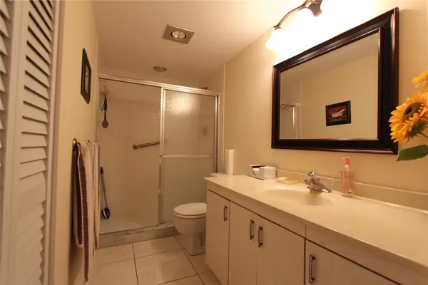a bathroom with a granite countertop sink toilet and shower