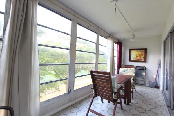 a dining room with furniture a rug and a large window