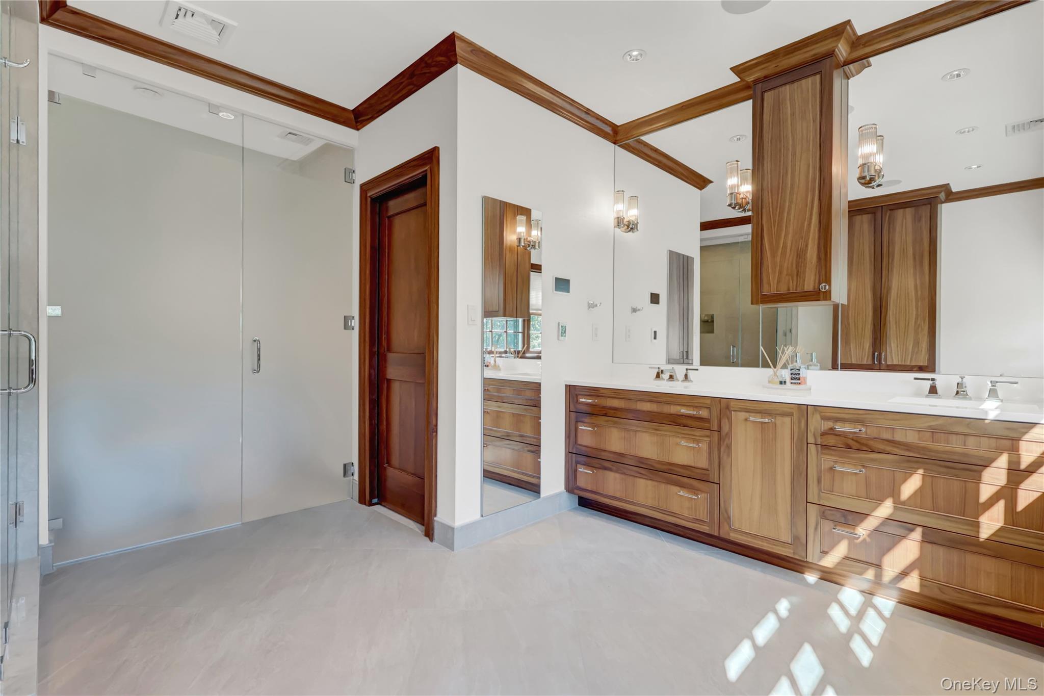 63 Dyke Road Setauket, NY 11733 - Photo 24 of 49 Full bathroom with ornamental molding, double vanity, a stall shower, and a chandelier