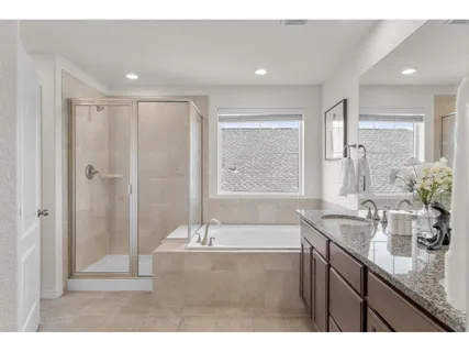 a bathroom with a granite countertop sink a large mirror and a bathtub