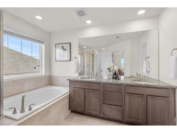 a bathroom with a tub a sink and mirror