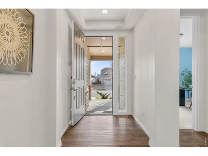 a view of a hallway with wooden floor and a living room