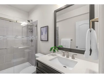 a bathroom with a sink vanity granite tub shower and a mirror