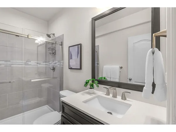 a bathroom with a sink vanity granite tub shower and a mirror