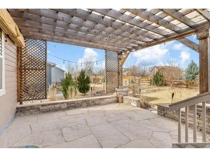 a view of a brick house with large windows and a small yard