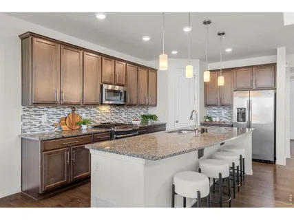 a kitchen with stainless steel appliances granite countertop a stove refrigerator sink and cabinets