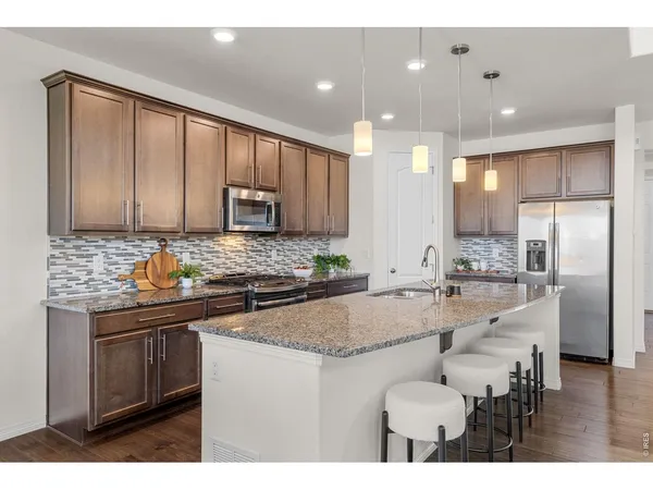 a kitchen with stainless steel appliances granite countertop a stove refrigerator sink and cabinets