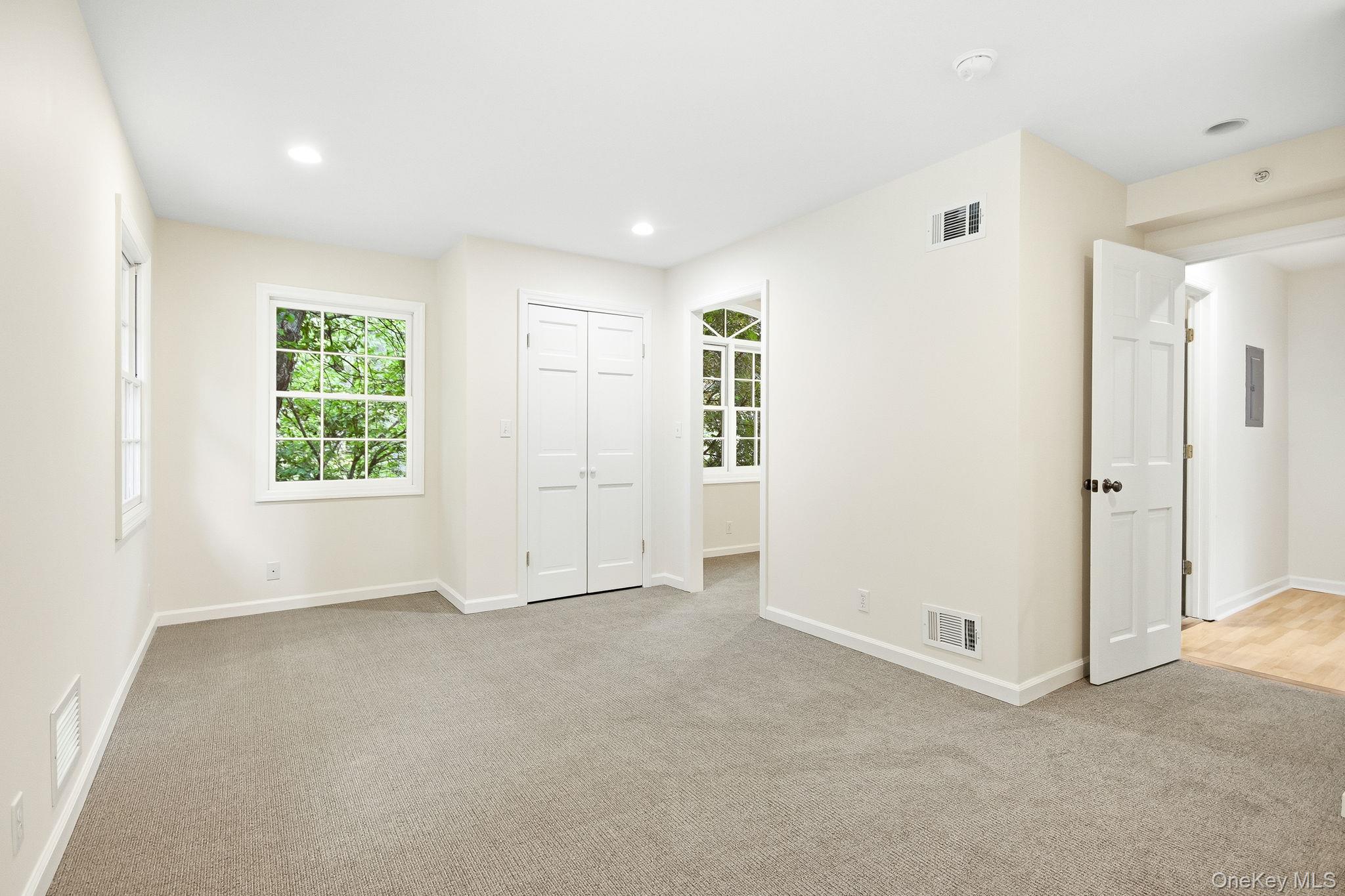 26 Century Ridge Road Purchase, NY 10577 - Photo 21 of 50 Second en-suite bedroom; carpeted room with recessed lighting, two sash windows, and white bi-fold closet doors