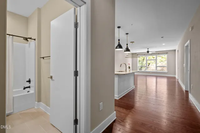 a kitchen with stainless steel appliances granite countertop a sink and a stove top oven with wooden floor