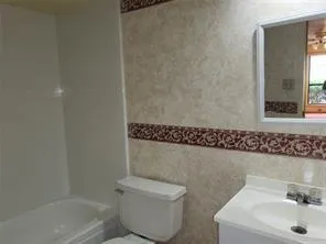 a bathroom with a sink a toilet and shower