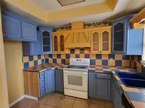 a kitchen with a stove sink and cabinets