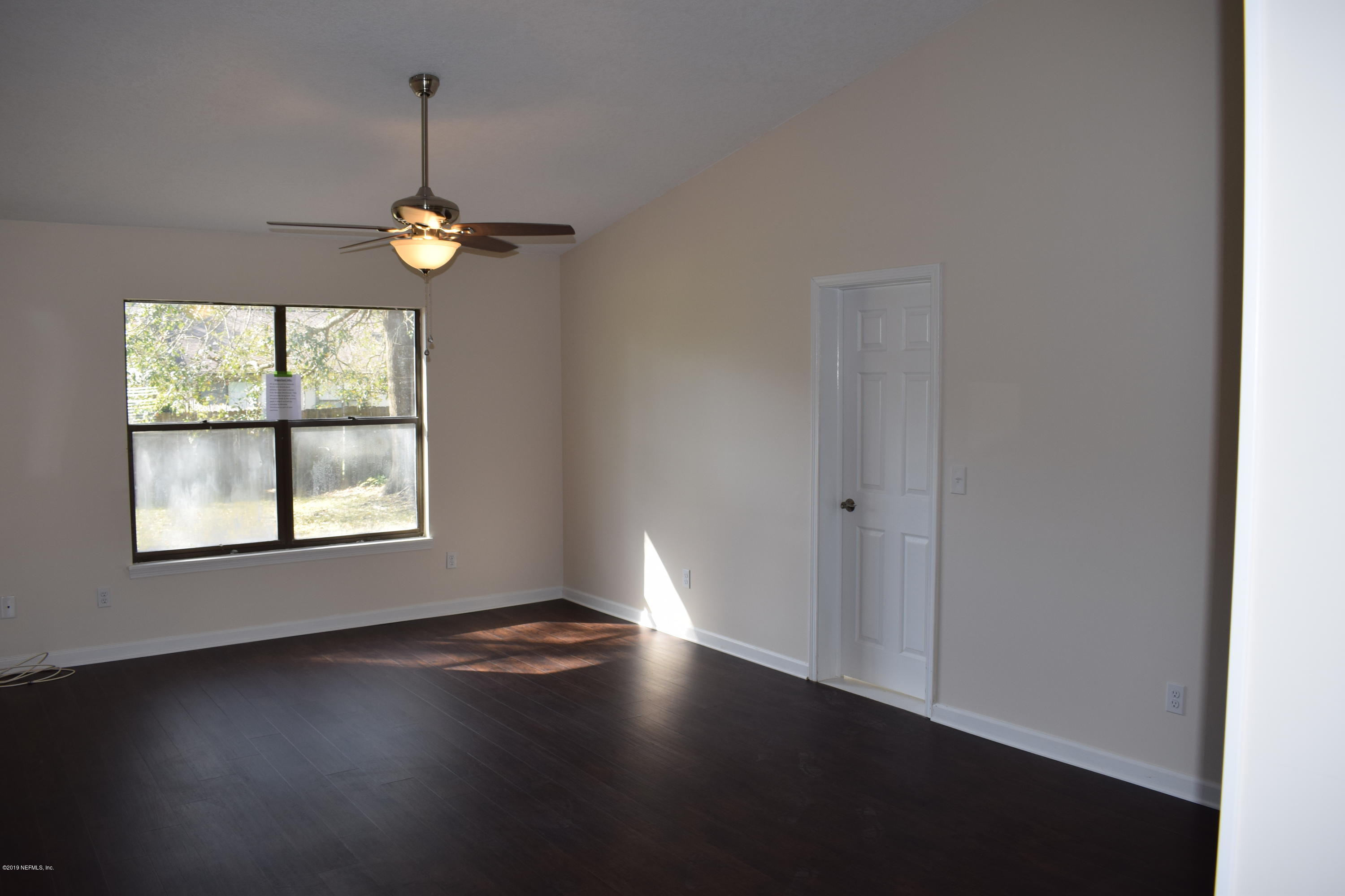 3422 Ricky Court Jacksonville, FL 32223 - Photo 6 of 10 an empty room with wooden floor and windows