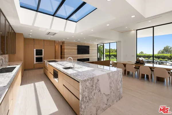 a bathroom with a granite countertop sink and a large mirror