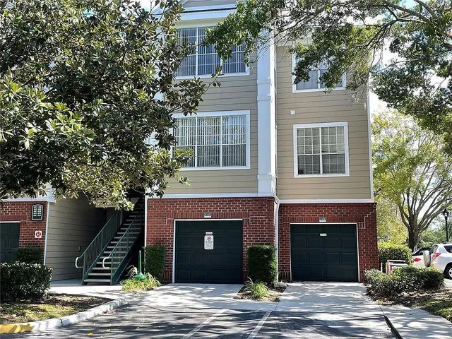 a front view of a house with a tree