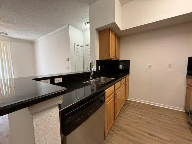 a kitchen with granite countertop a sink and a stove top oven