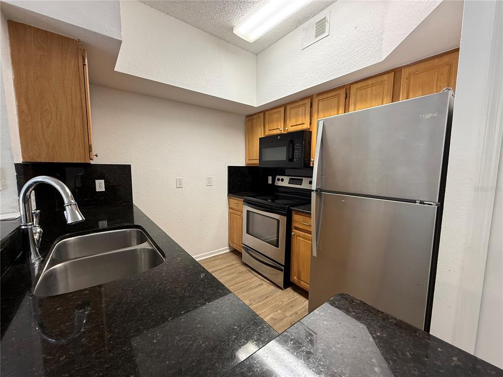 Undisclosed Address Orlando, FL 32821 - Photo 8 of 23 a kitchen with a refrigerator a stove a sink and a window