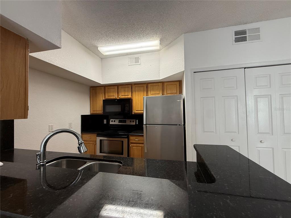 Undisclosed Address Orlando, FL 32821 - Photo 9 of 23 a kitchen with a refrigerator and a sink