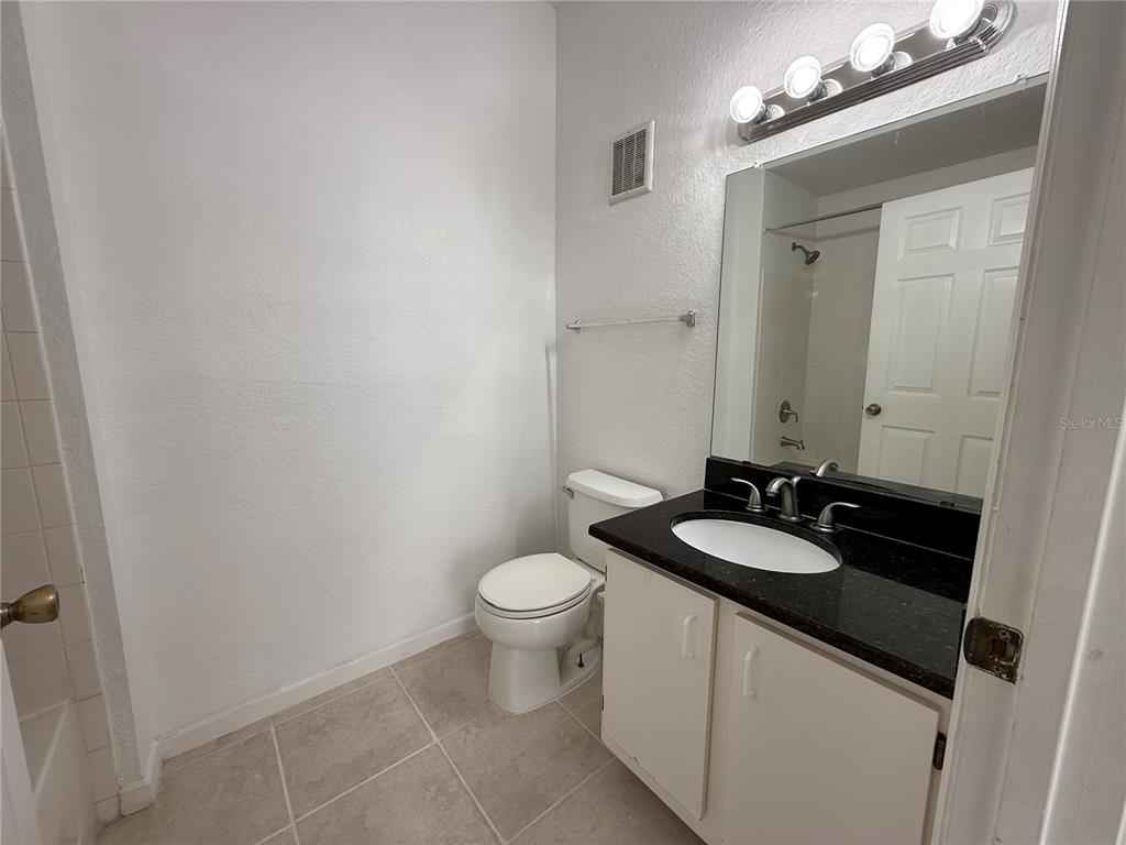 Undisclosed Address Orlando, FL 32821 - Photo 10 of 23 a bathroom with a granite countertop sink a toilet and a mirror