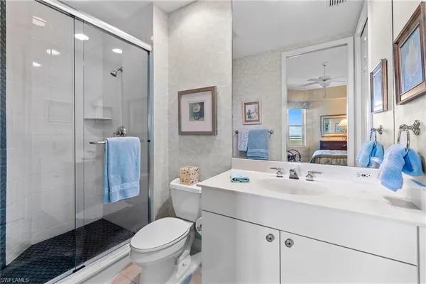 a bathroom with a sink toilet mirror and shower