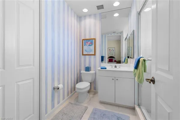 a bathroom with a sink vanity mirror and toilet