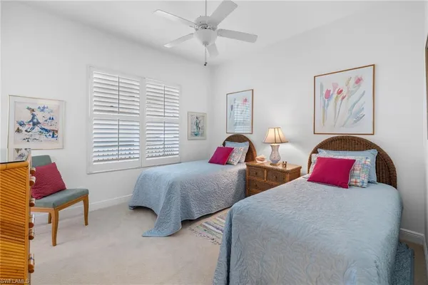 a bedroom with two beds and a painting on the wall
