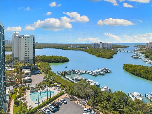 an aerial view of ocean and residential houses with outdoor space