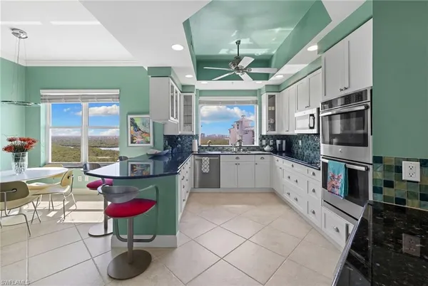 a large kitchen with stainless steel appliances kitchen island granite countertop a sink and cabinets