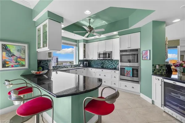 a kitchen with stainless steel appliances granite countertop a sink dishwasher stove and cabinets with wooden floor