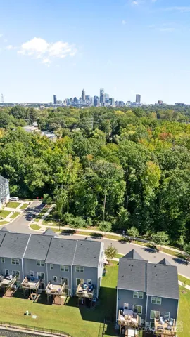 an aerial view of residential houses with outdoor space and trees