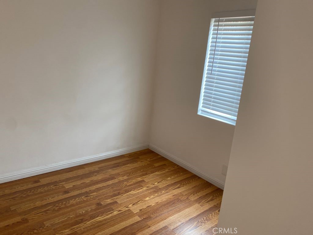 1140 1/2 South Oxford Avenue Los Angeles, CA 90006 - Photo 5 of 14 a view of a room with wooden floor and a window