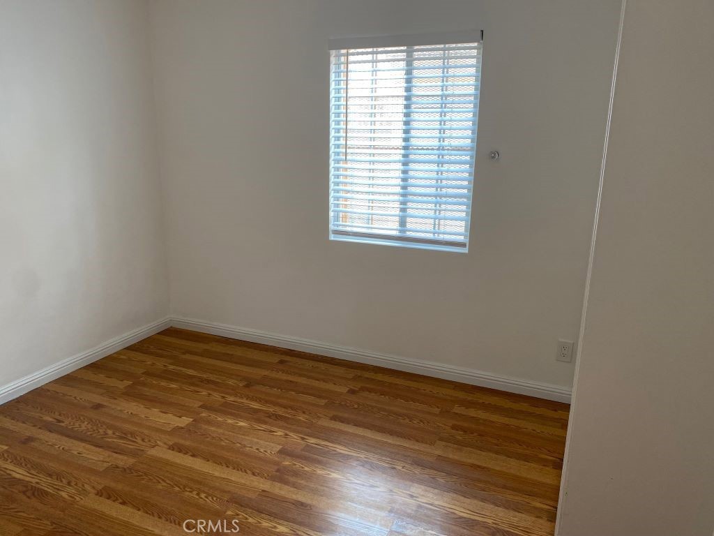 1140 1/2 South Oxford Avenue Los Angeles, CA 90006 - Photo 9 of 14 an empty room with wooden floor and windows