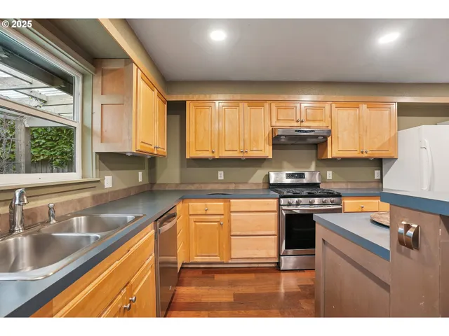 a kitchen with stainless steel appliances granite countertop a sink stove and cabinets