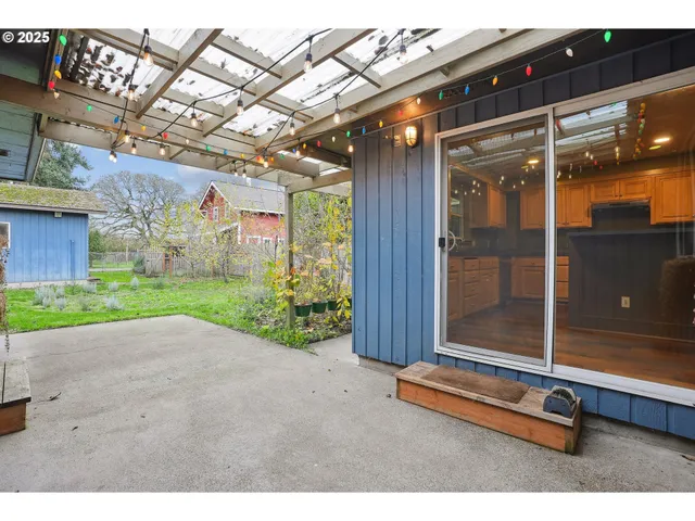 a backyard of a house with barbeque oven table and chairs