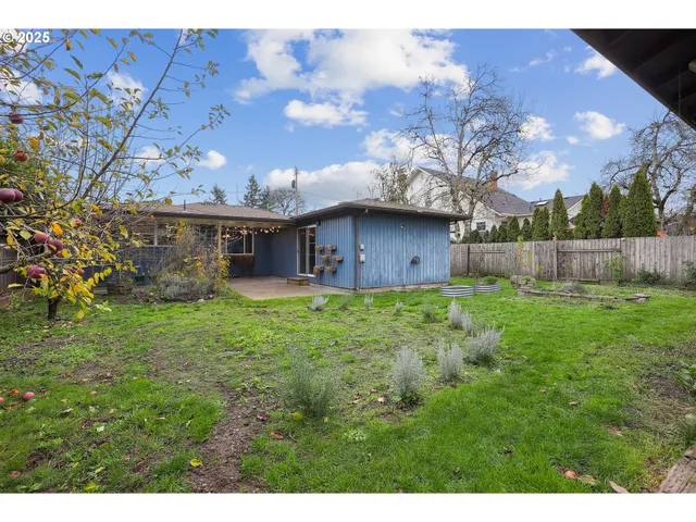 a view of a house with a big yard and large trees