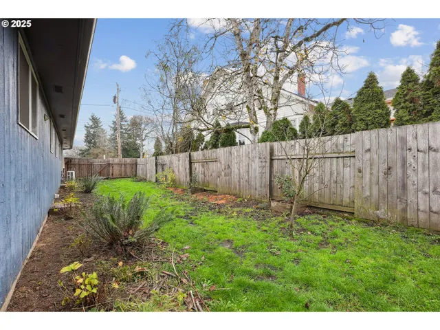 a view of backyard with wooden fence