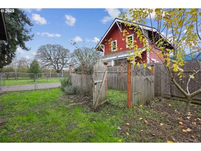 a view of a house with a yard and wooden fence