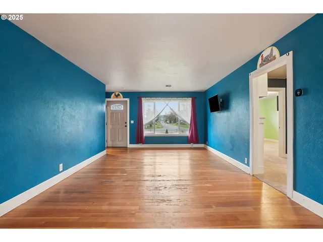 a view of an empty room with wooden floor