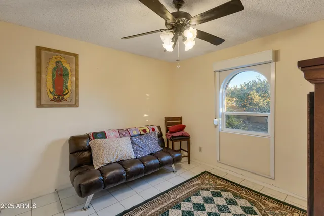 a living room with furniture a rug and a floor to ceiling window