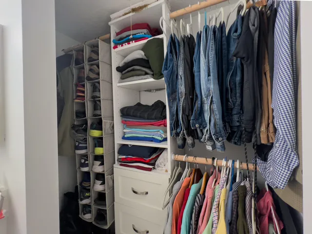 a view of walk in closet with clothes and shoes