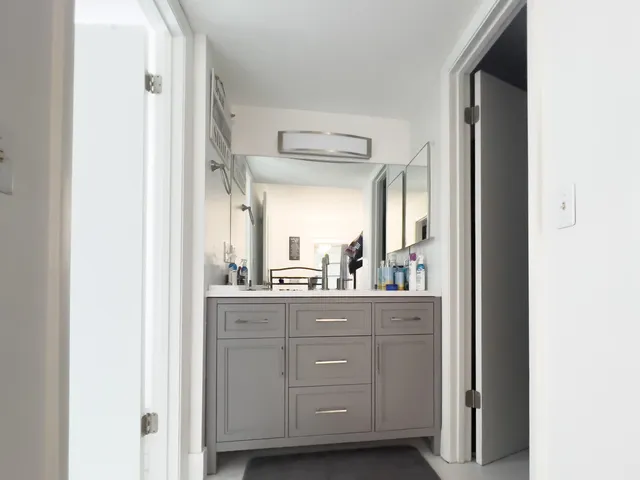 a bathroom with a granite countertop sink mirror and cabinets