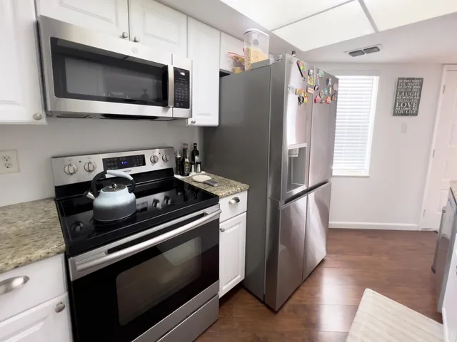 a kitchen with stainless steel appliances granite countertop a refrigerator microwave and sink