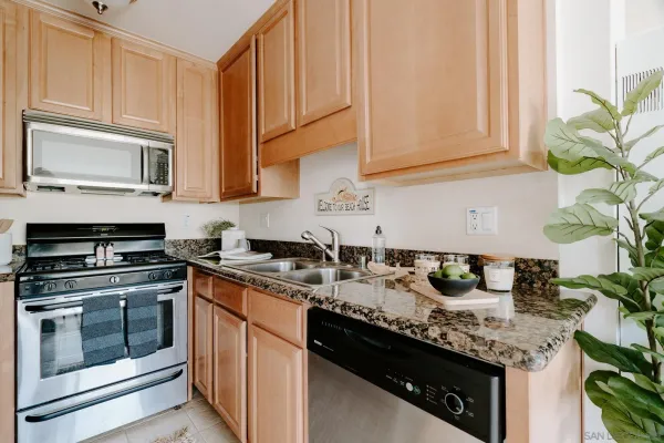 a kitchen with stainless steel appliances granite countertop a sink stove and microwave