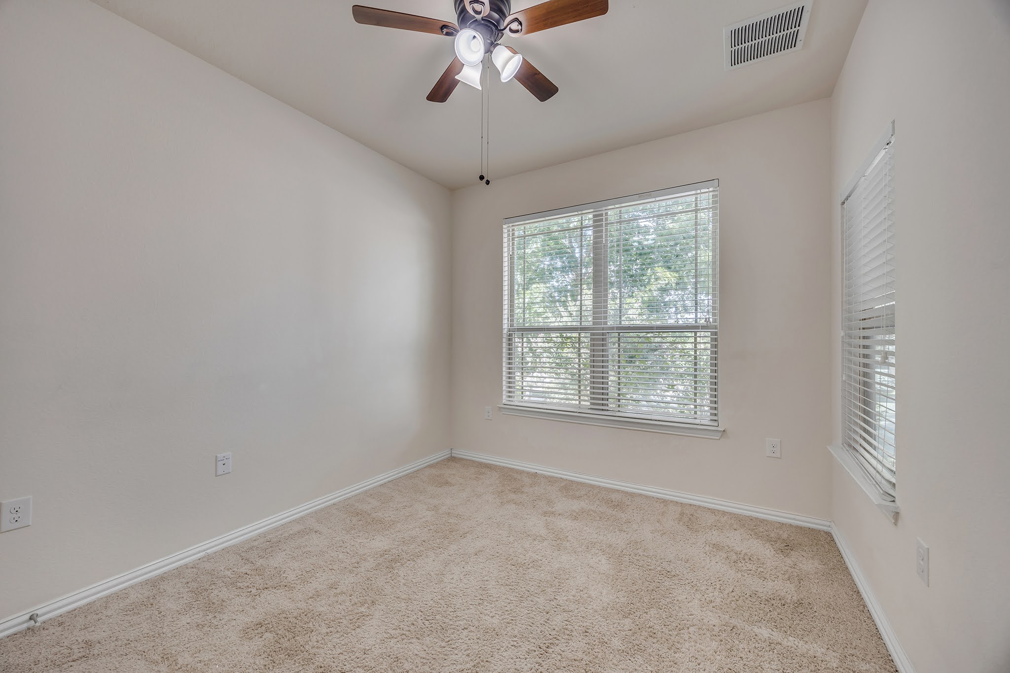 7212 Vail Ridge Street Austin, TX 78744 - Photo 9 of 26 Comfortable carpeted bedroom with a generous window inviting natural light, perfect for relaxation.