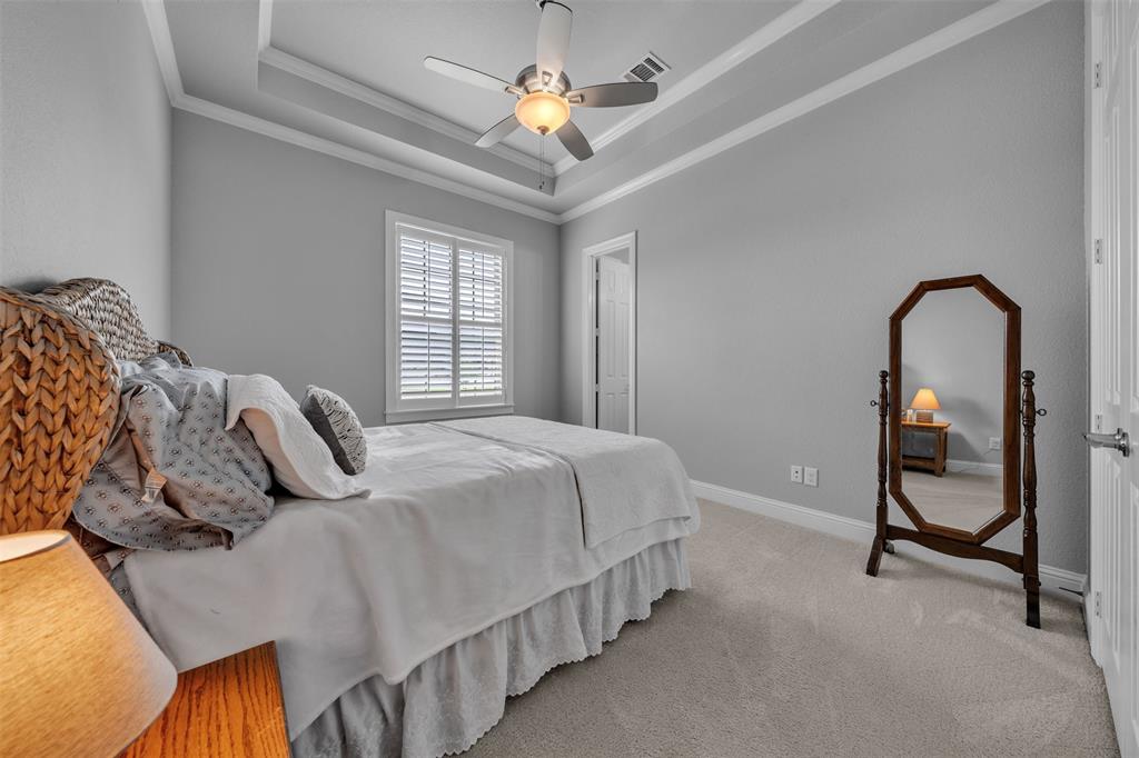 1060 Waters Edge Court Oak Point, TX 75068 - Photo 15 of 40 a bedroom with bed and a chandelier