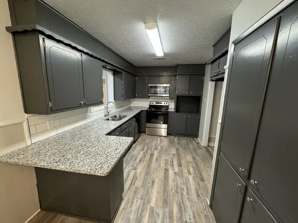 a view of kitchen with sink microwave and refrigerator