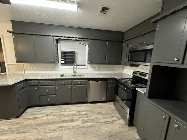 a kitchen with a sink stove and microwave