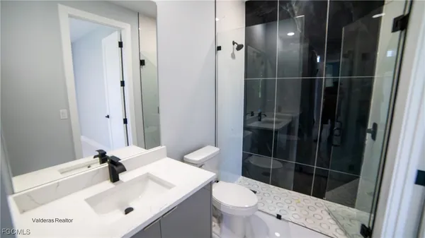 a bathroom with a sink a toilet and shower