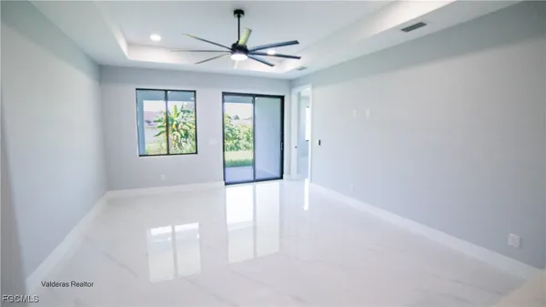 an empty room with windows and ceiling fan