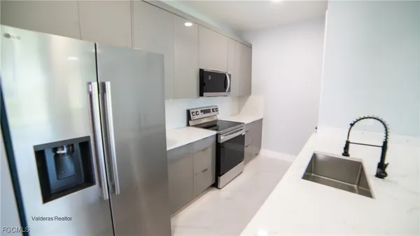 a kitchen with stainless steel appliances a refrigerator stove and microwave