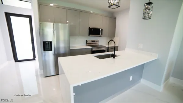 a kitchen with stainless steel appliances a refrigerator sink and microwave